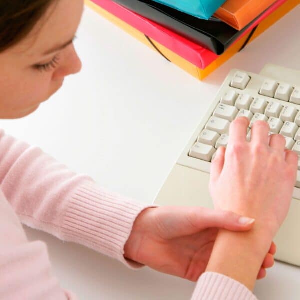 woman looks at wrist in pain scaled