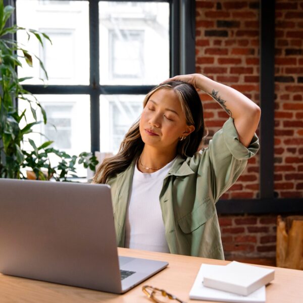 woman stretches whilst at her desk scaled