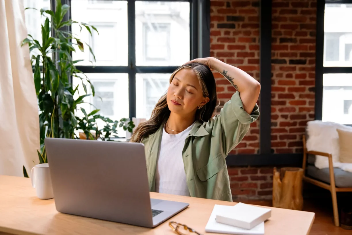 woman stretches whilst at her desk