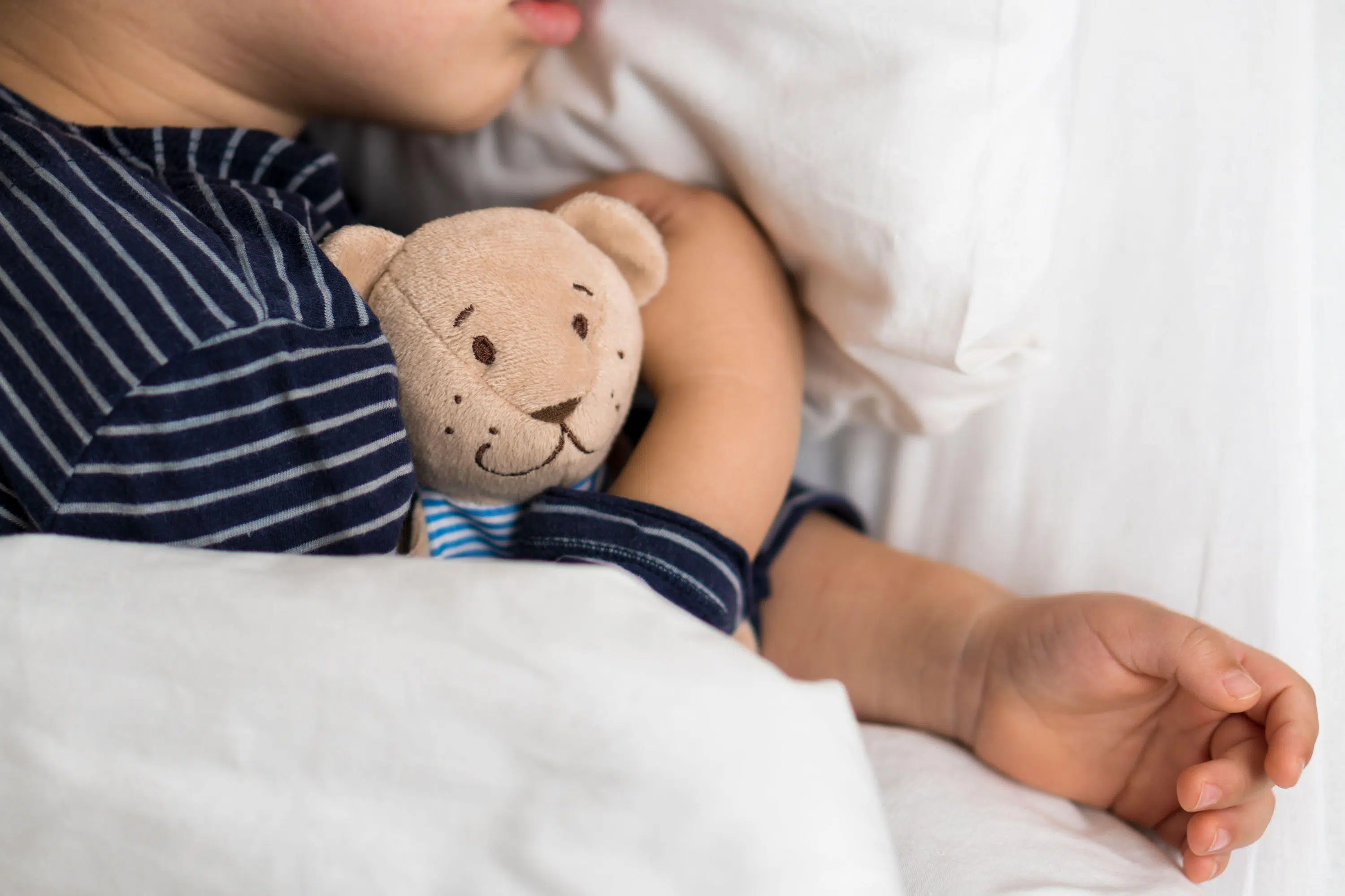 Young child cuddles teddy bear scaled
