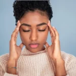 woman holds side of head scaled