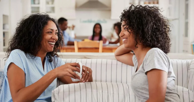Two women share a joke over coffee scaled e1646312517496