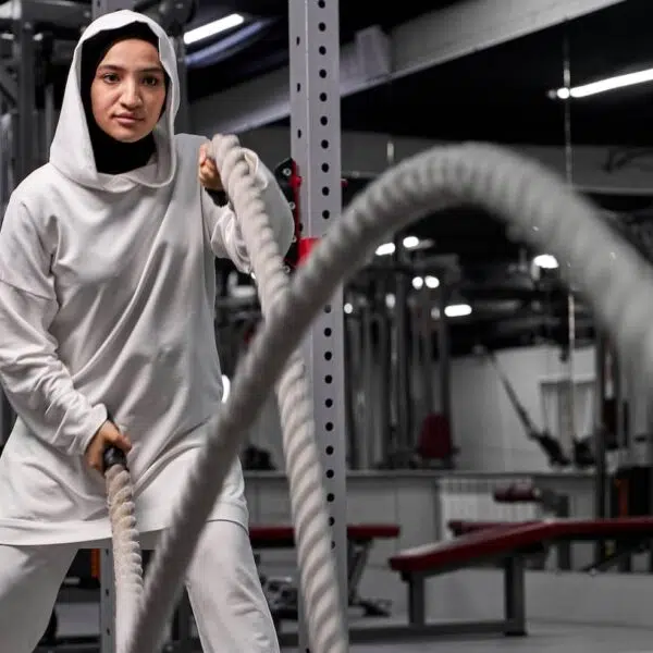 Muslim athletic woman working out with ropes at cross fit gym e1648489953587