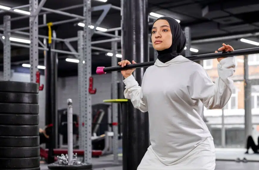 muslim woman lifts heavy weights in gym e1648664208211