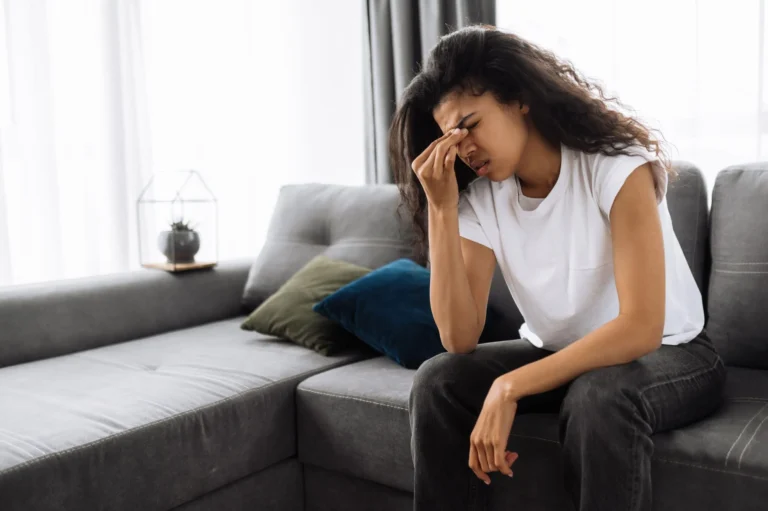 woman sits with hand to her head scaled