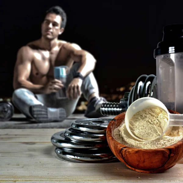 Fit man sits looking at protein powder drink