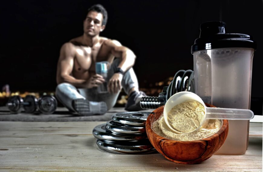 fit man sits looking at protein powder drink