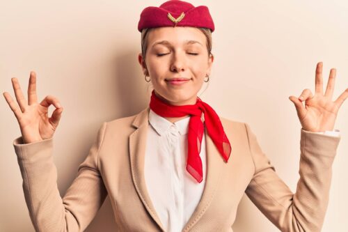 stewardess with eyes closed doing meditation gesture with fingers