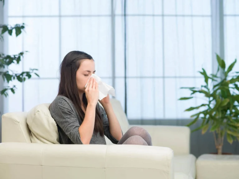 woman holds tissue to nose scaled
