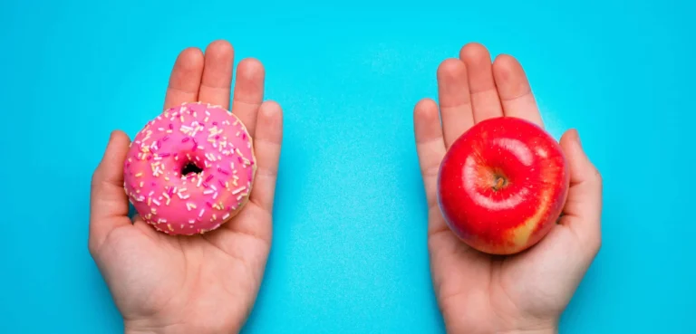 a pair of hands hold donut and apple in each