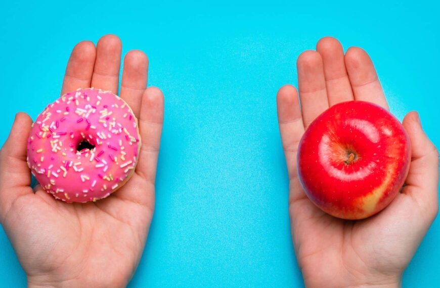 a pair of hands hold donut and apple in each