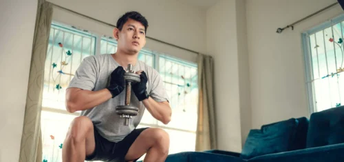 fit man holds a squat scaled e1651745863443