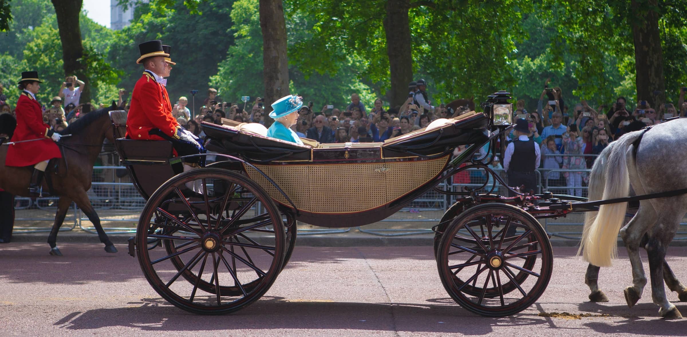 The queen travels in horse drawn carriage