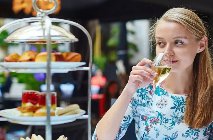 Woman drinks champagne with afternoon tea