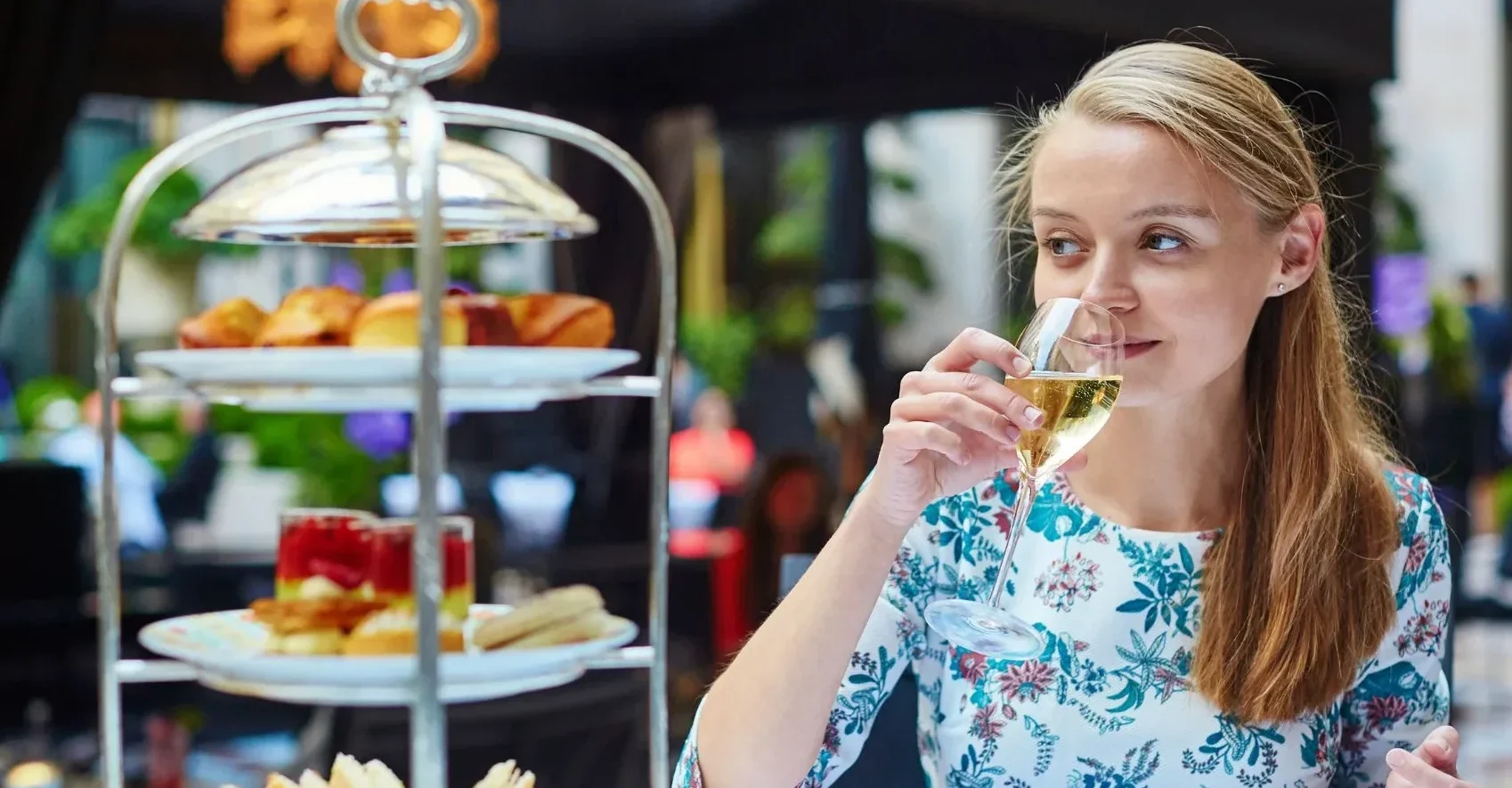 Woman drinks champagne with afternoon tea