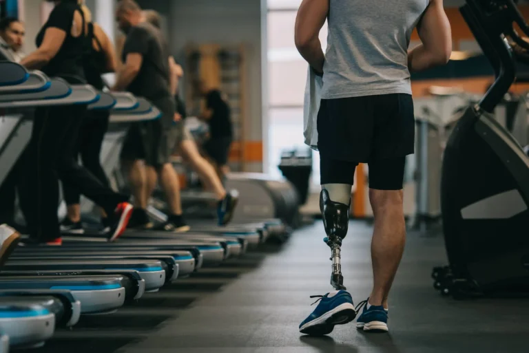 athletic sportsman with artificial leg in gym