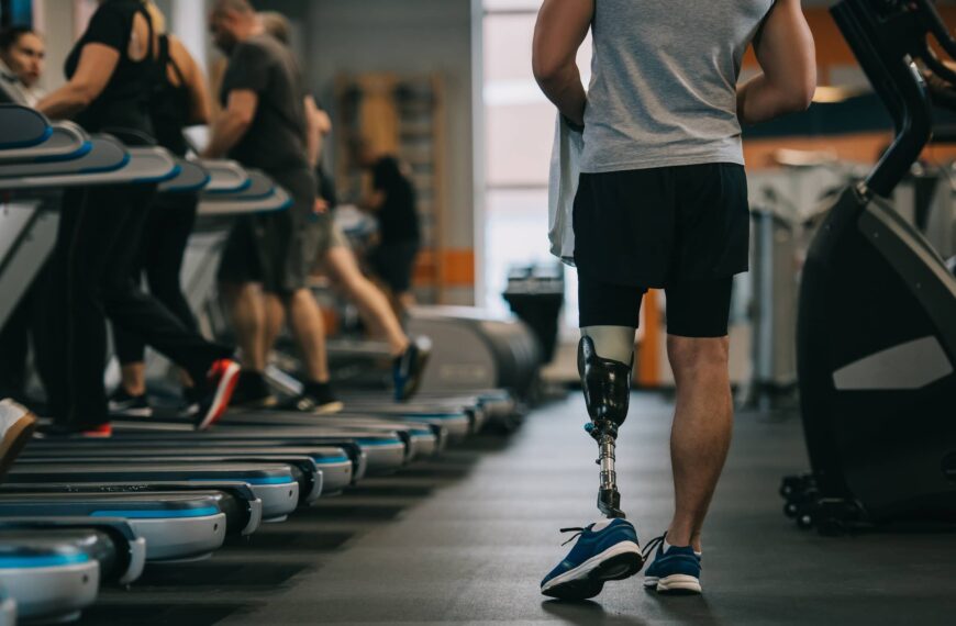 athletic sportsman with artificial leg in gym