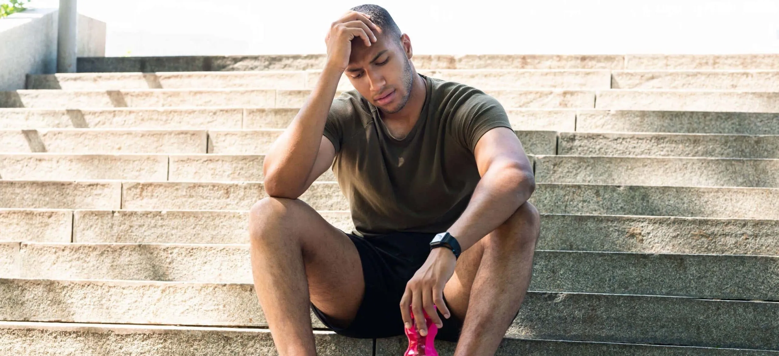 fit guy sits sweating hot on steps scaled