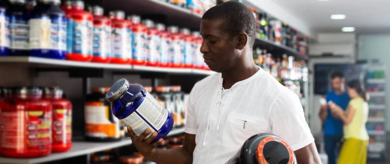 young man checks out supplement packaging