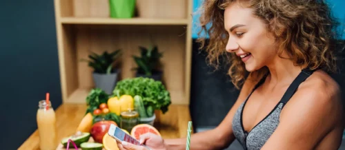 woman enjoying and using phone for count calories at home kitchen 1