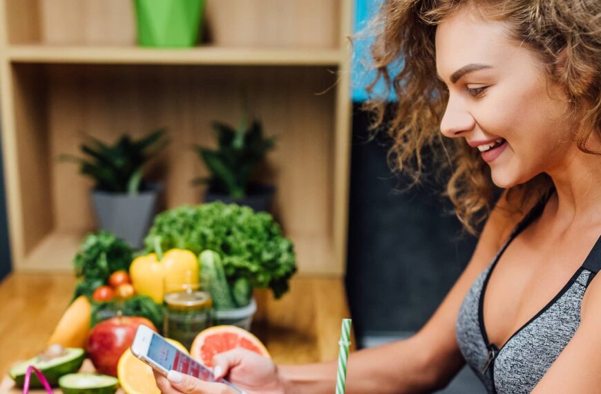 woman enjoying and using phone for count calories at home kitchen 1