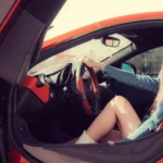 woman in denim dress driving expensive car