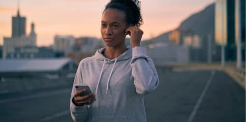 young fit woman holds phone in hand