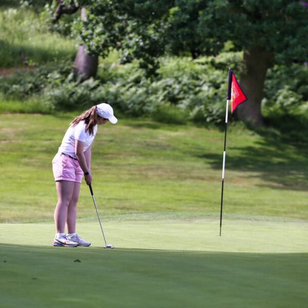 young golfer on green putting