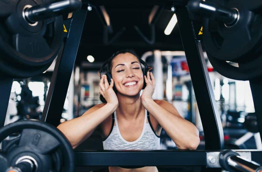 fit woman listens to her music in the gym scaled