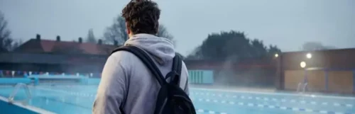 man walks by swimming pool