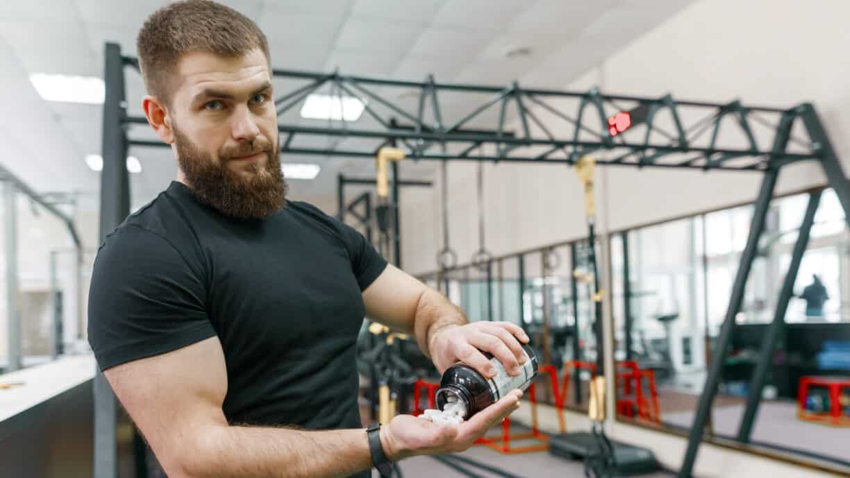 muscular man showing sports and fitness supplements