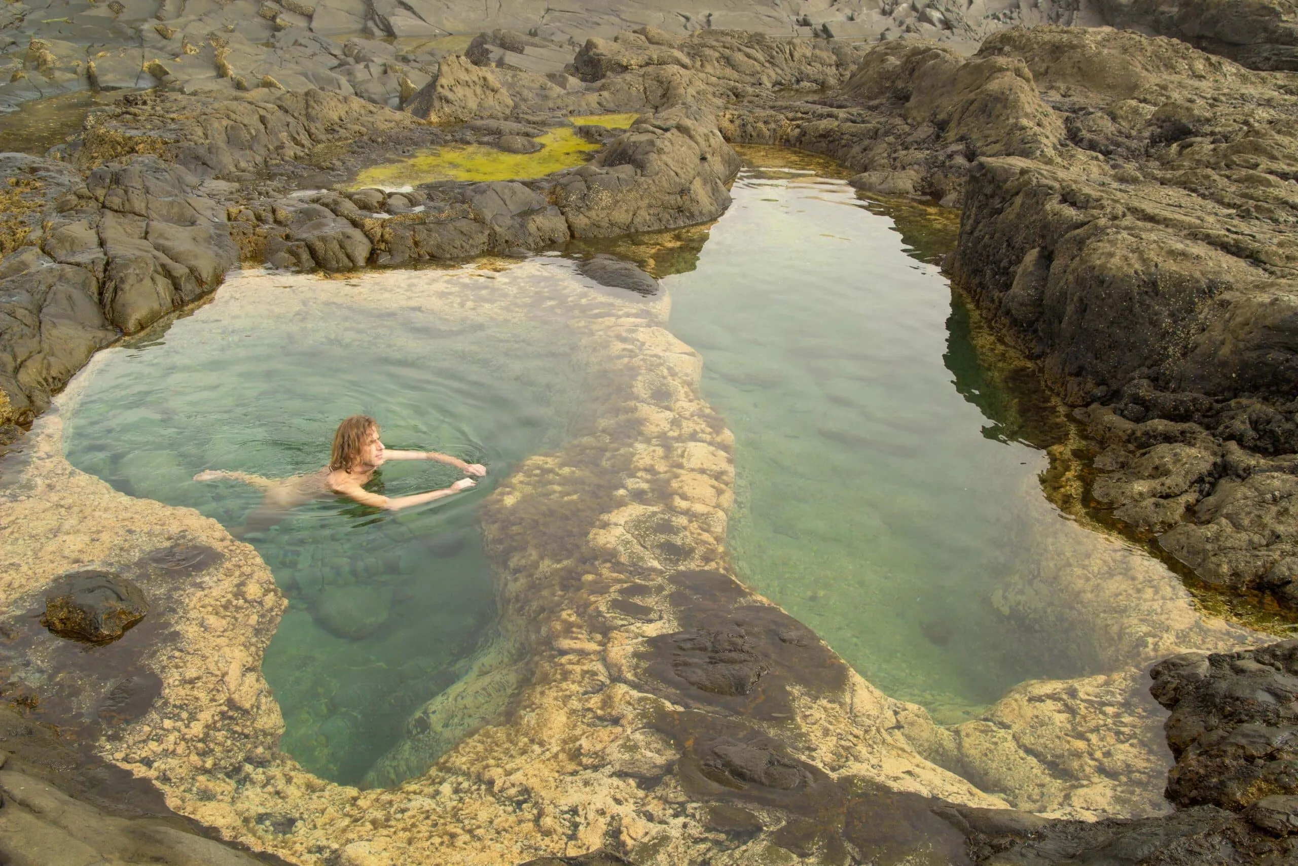 person swims naked in water scaled