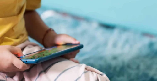 youngster holds mobile device scaled