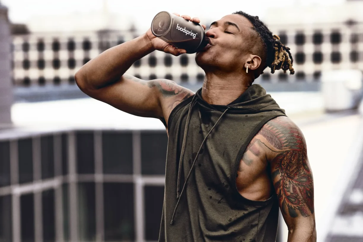 Athlete drinks from Foodspring bottle