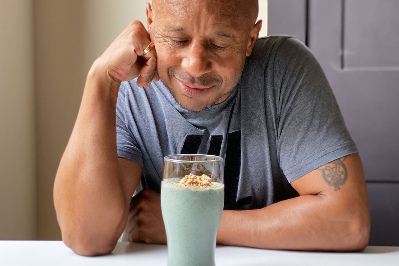 Man looks down at his smoothie