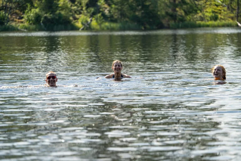 people swim in outdoor water scaled