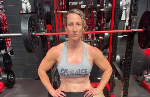 Kat Merchant stands in front of gym equipment