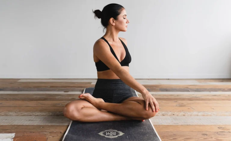 woman practises yoga on mat