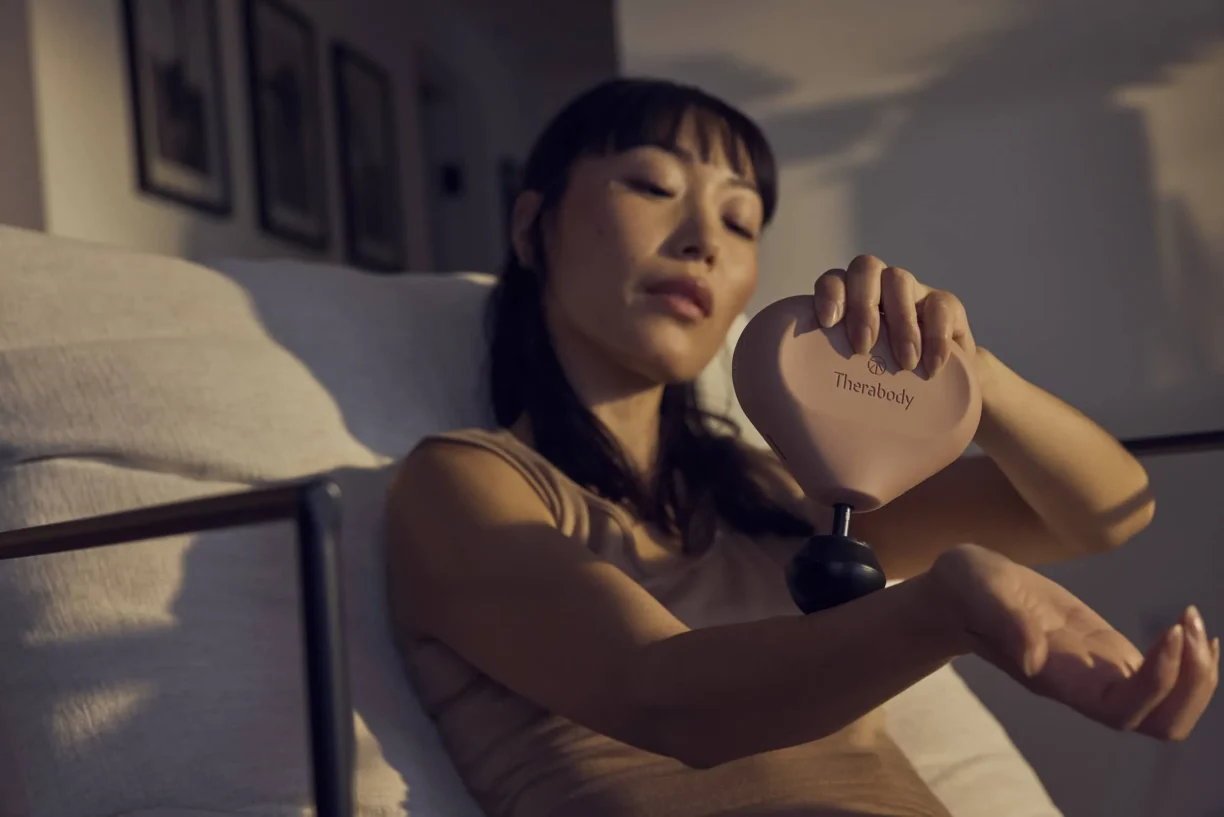 woman uses therabody mini massager on wrist