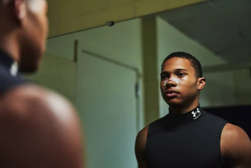 young athlete looks in mirror