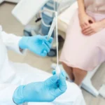 Woman having test for sexually transmitted disease with doctor