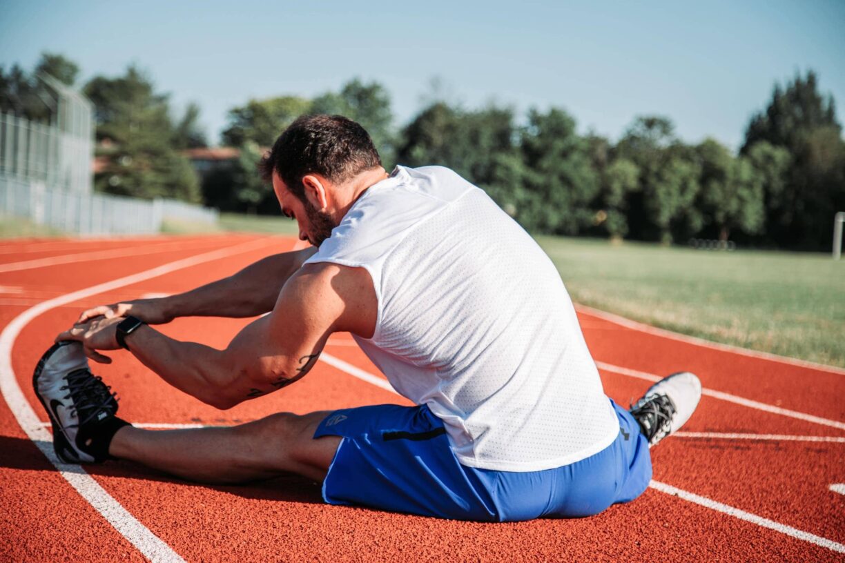 Athlete stretches on running track