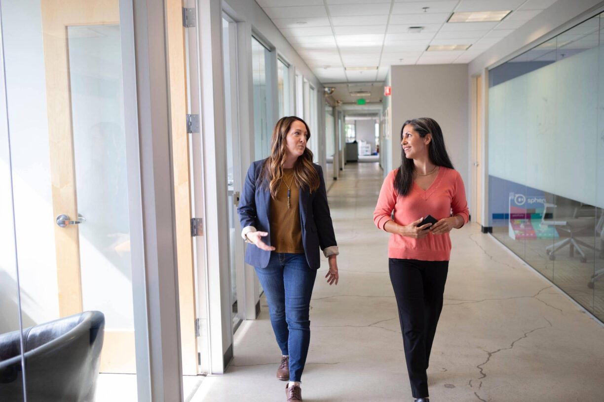 people walk along office corridor