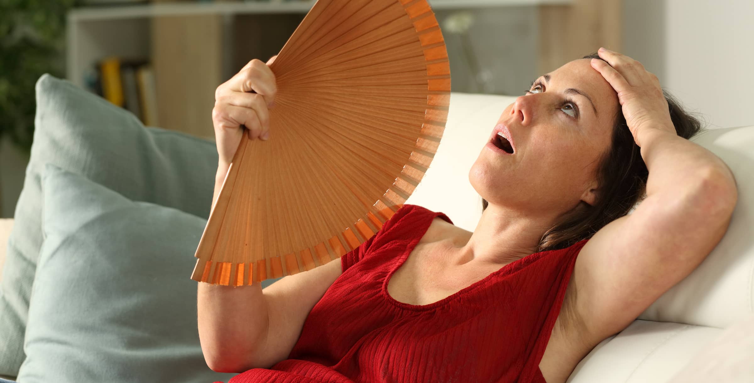 Woman fanning herself suffering heat at home