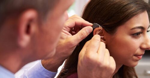 woman having hearing aid fitted:adjusted