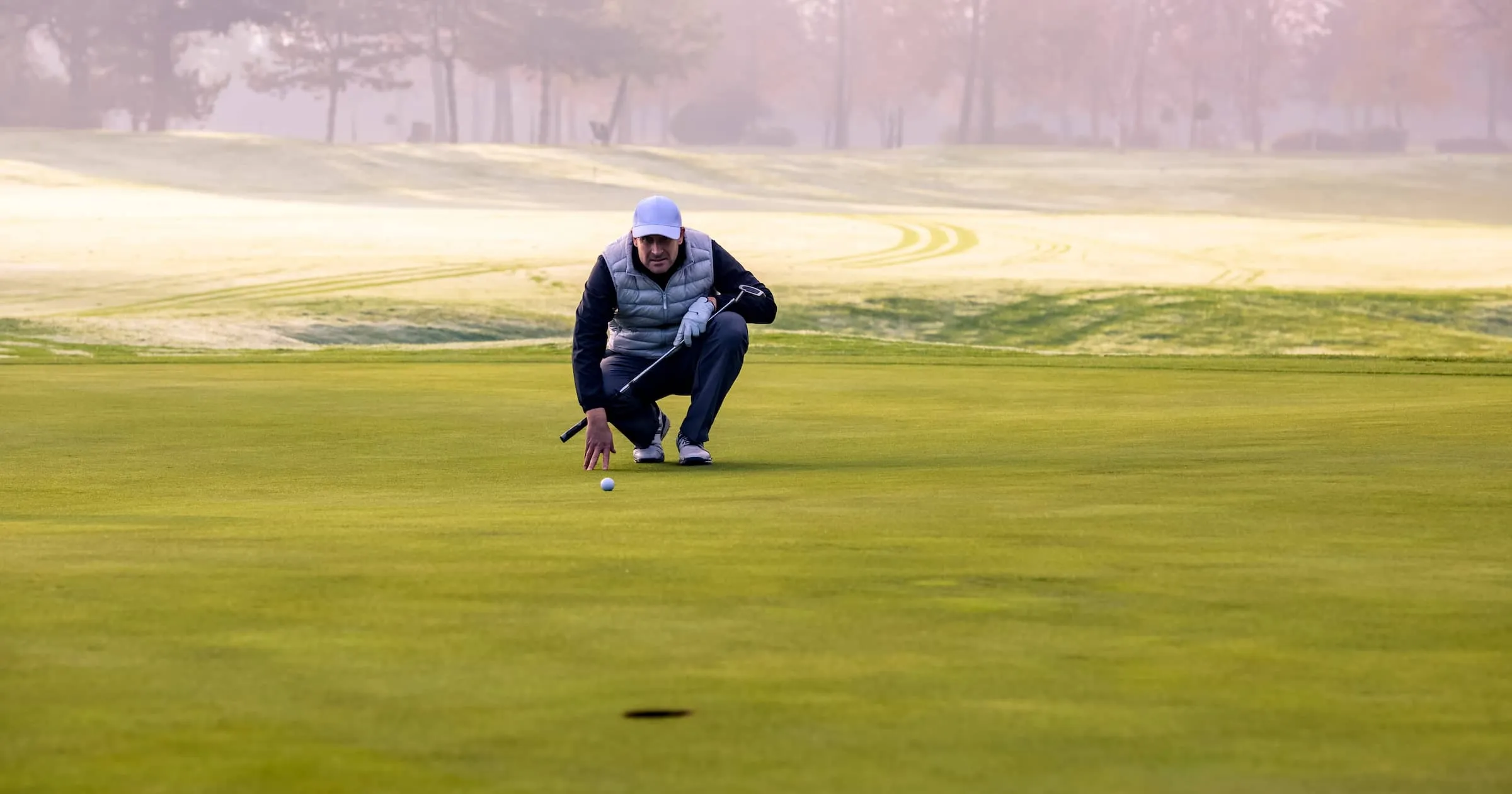 Close-up of a golf player on course aiming for put shot during a tournament