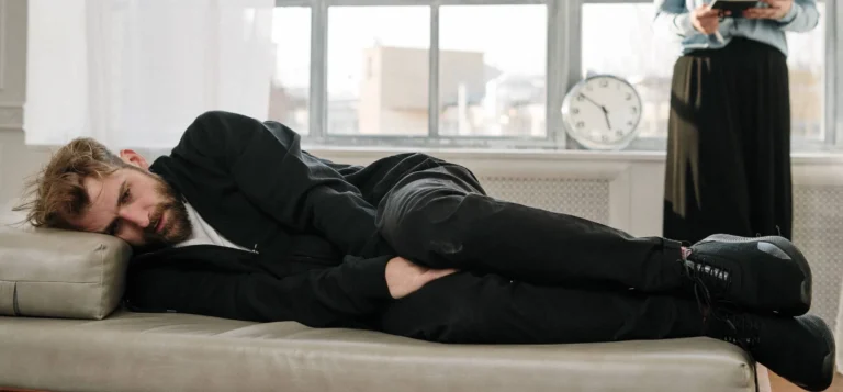 man lays on bed looking sad