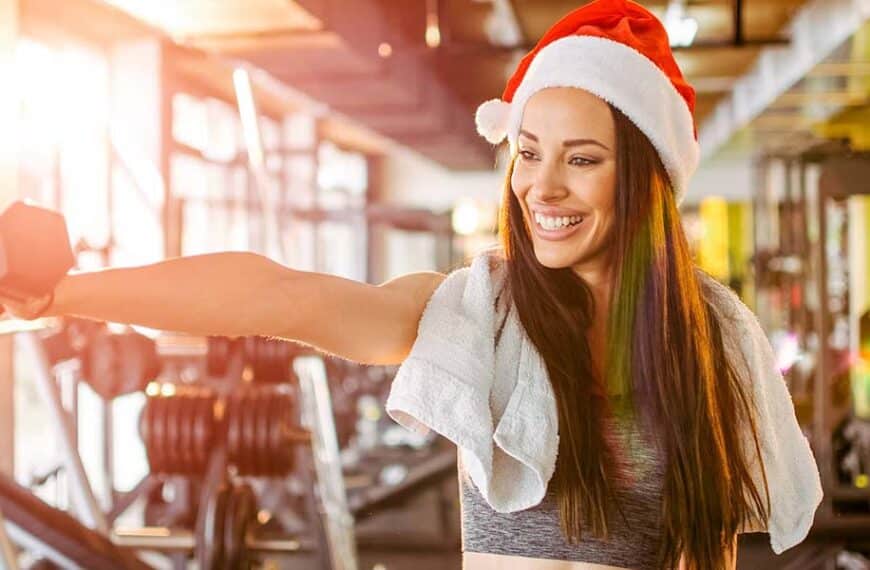 young woman with christmas hat and dumbbells