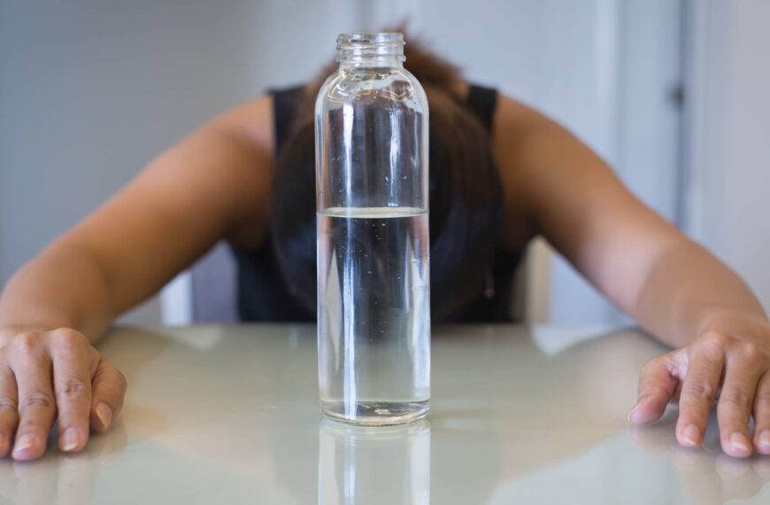 Hungry frustrated woman trying to lose weight, with a glass of water. Intermittent fasting