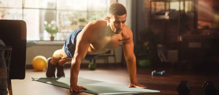 Strong Athletic Man Does Shirtless Workout at Home Gym, Doing Push Ups. Lean Fit Muscular Mixed Race Sportsman Staying Healthy, Training at Home. Sweat and Determination lead to Success
